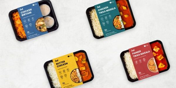 Fyra färdigrätter i svarta plasttråg med olika indiska maträtter sedda ovanifrån. Fyra färdigrätter i svarta plasttråg med olika indiska maträtter sedda ovanifrån.