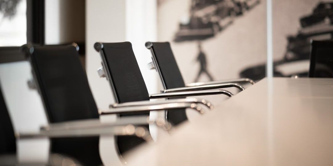 Modernt mötesrum med svarta stolar och ett långt konferensbord