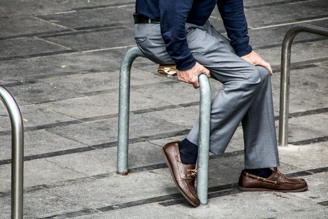 Person i kontorskläder sitter grensle över ett metallräcke
